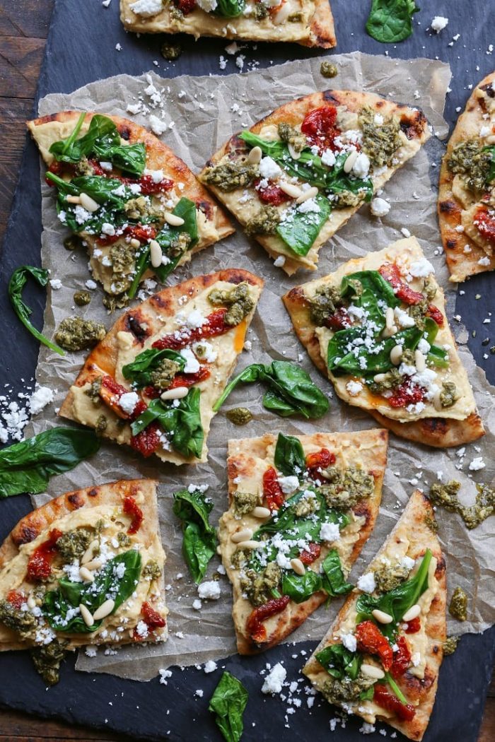 Hummus Flatbread with Sun-Dried Tomatoes, Spinach, and Pesto from The Roasted Root